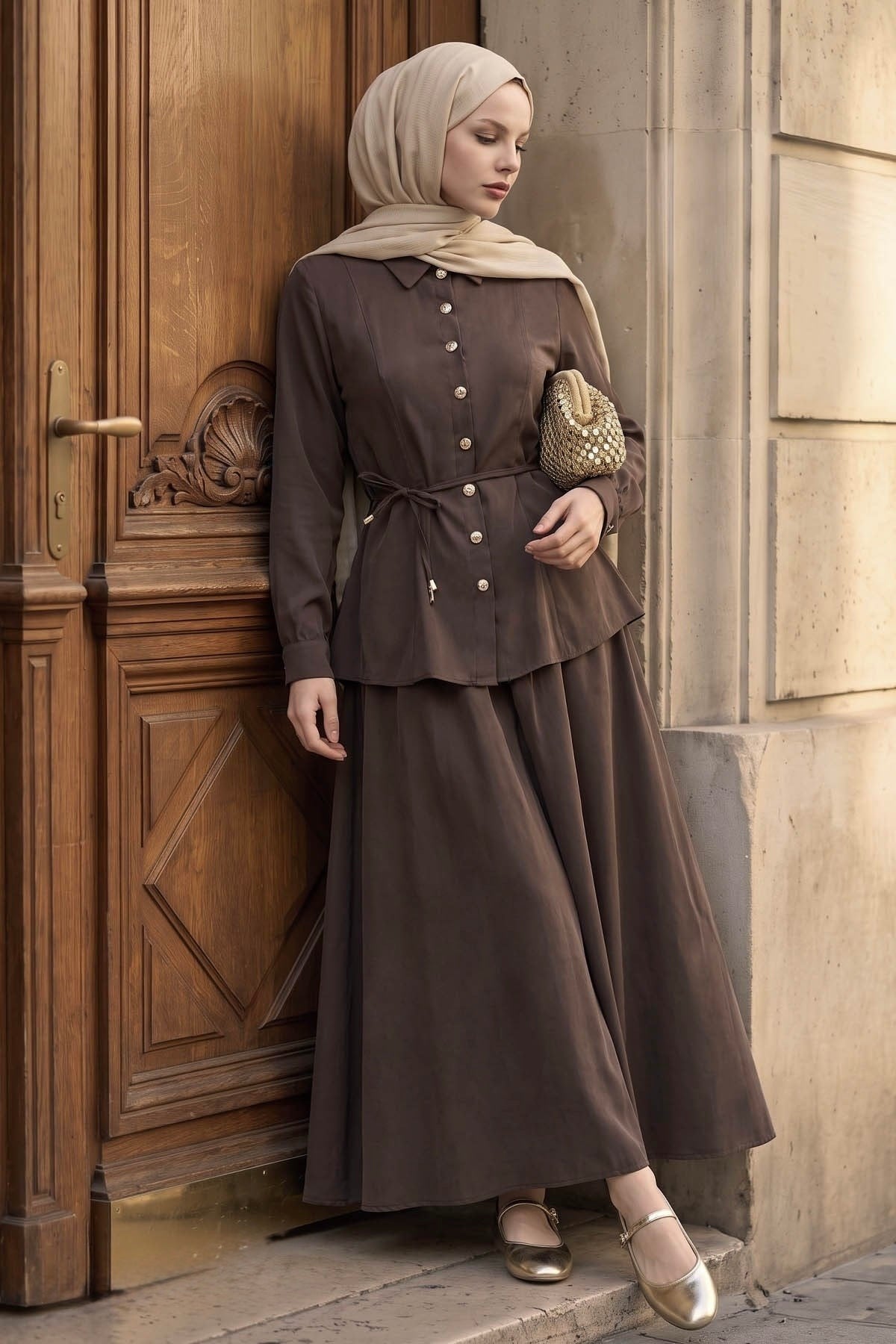 Ayla modest skirt set in brown styled with a gold clutch, side view