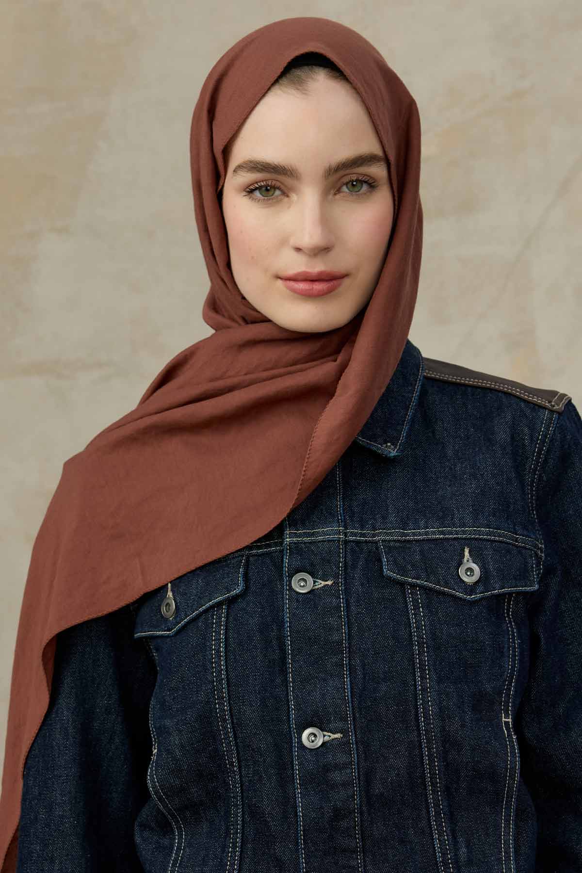 Woman wearing the rust Comfort Cotton Hijab with a denim jacket, front view
