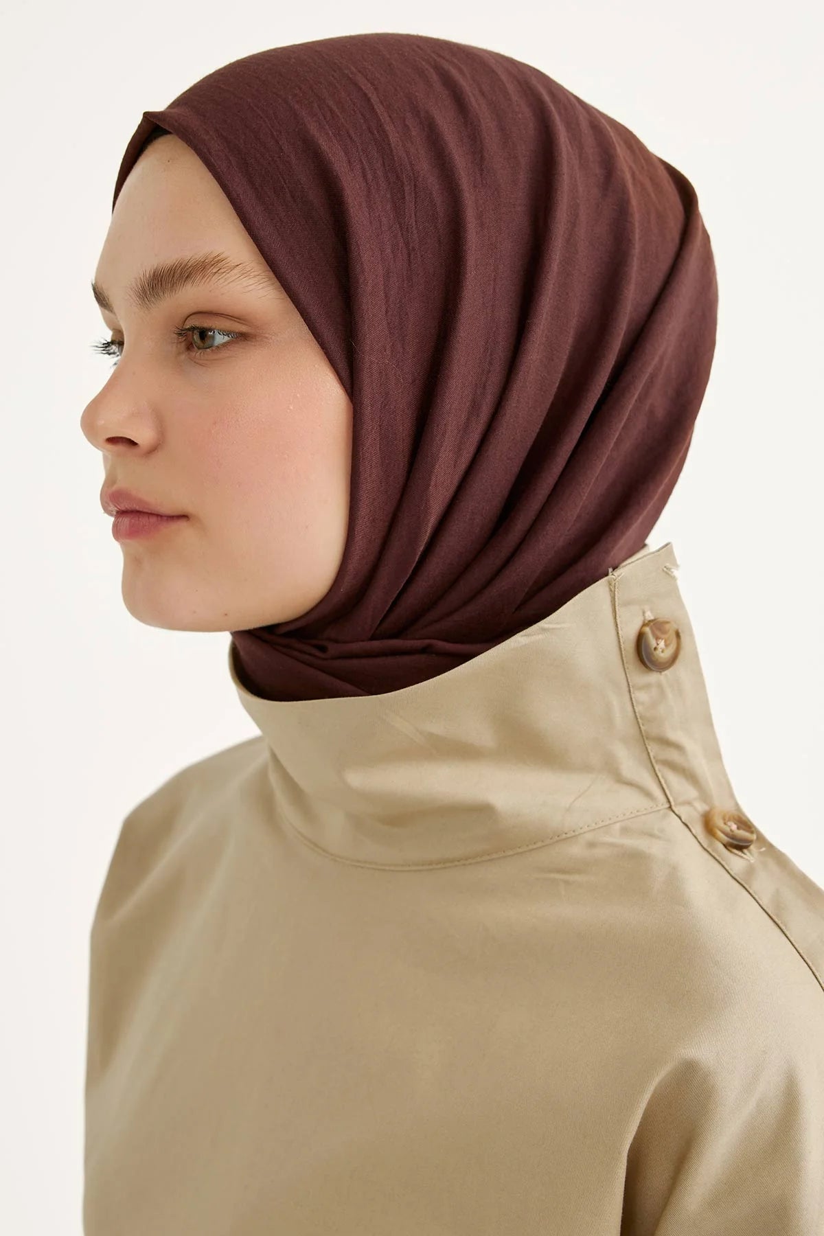 Plum Comfort Cotton Hijab shown in side profile with a beige trench coat