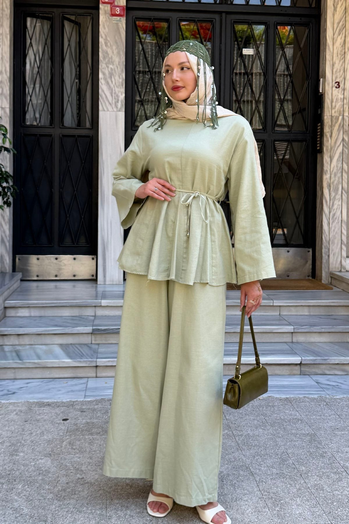 Willow linen set in light green styled with a green handbag, front view