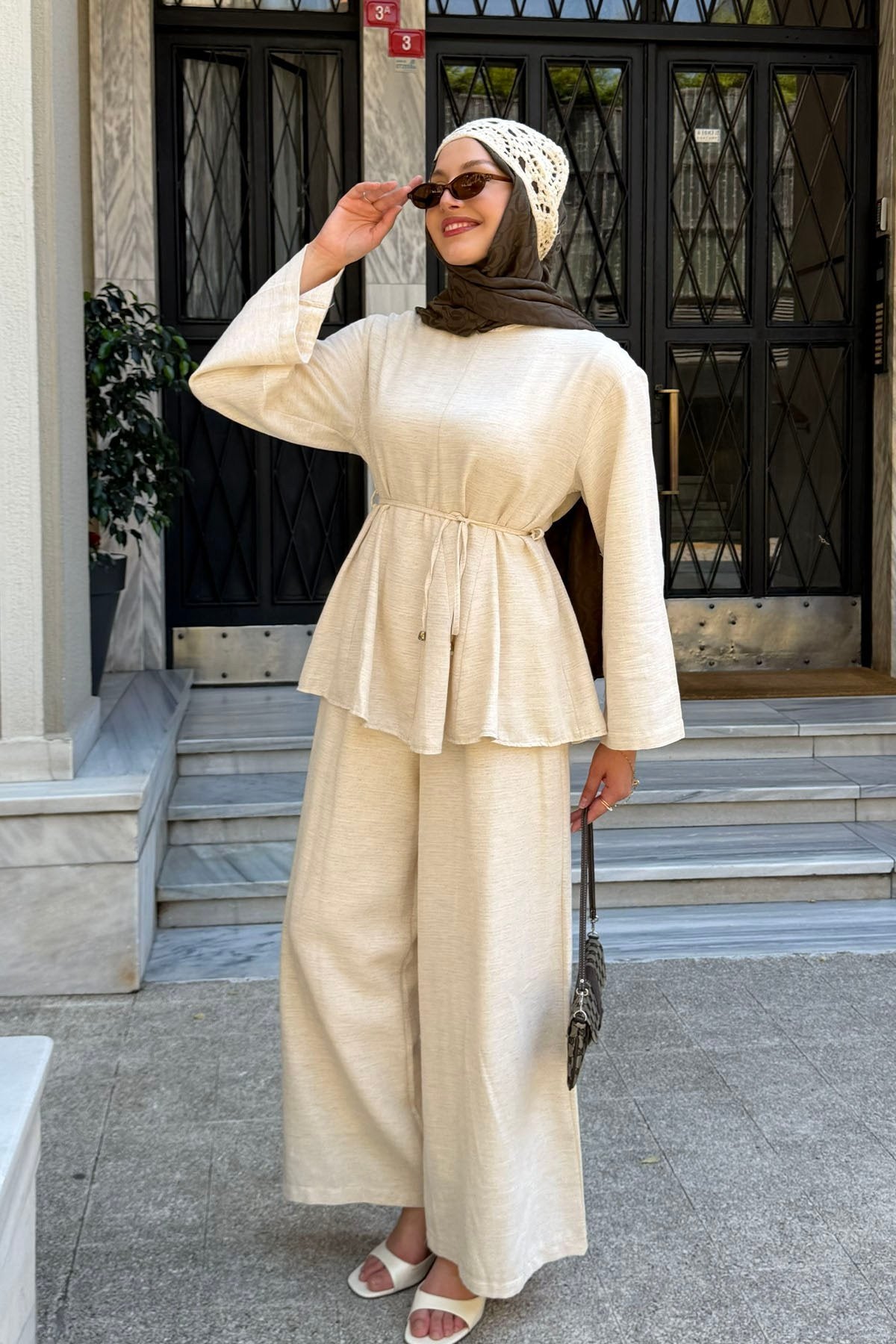 Woman in a hijab wearing the Willow cotton linen set in beige: tie-waist top and relaxed wide-leg pants