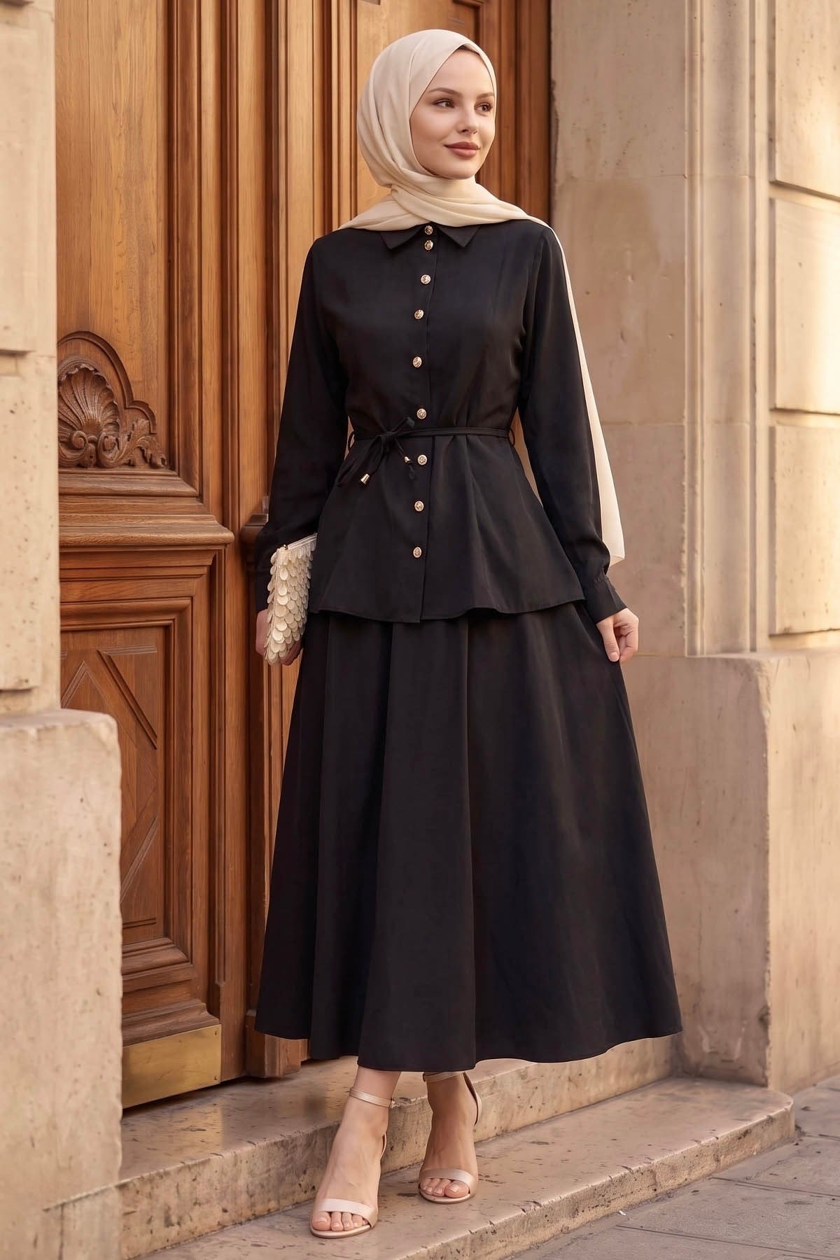 Ayla modest skirt set in black styled with a clutch, side view