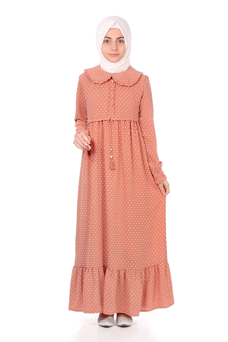 Model in a white hijab wearing the Zara girls' modest maxi dress in peach polka dot with Peter Pan collar and ruffle hem