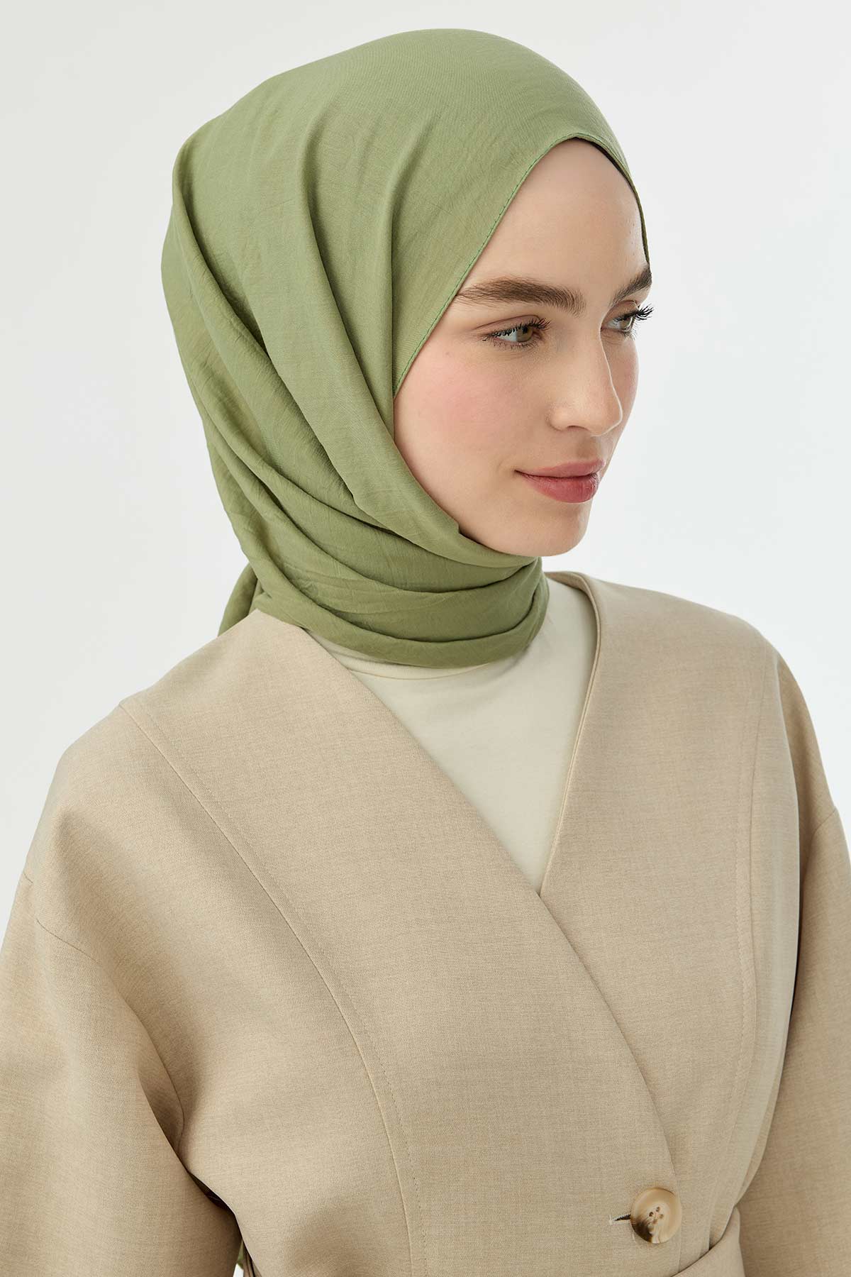 Woman wearing the pistachio Comfort Cotton Hijab with a beige wrap cardigan