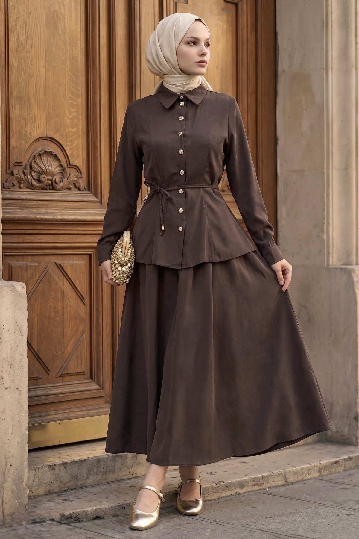Woman in a hijab wearing the Ayla modest skirt set in brown: tie-waist button-front shirt and A-line maxi skirt, front view