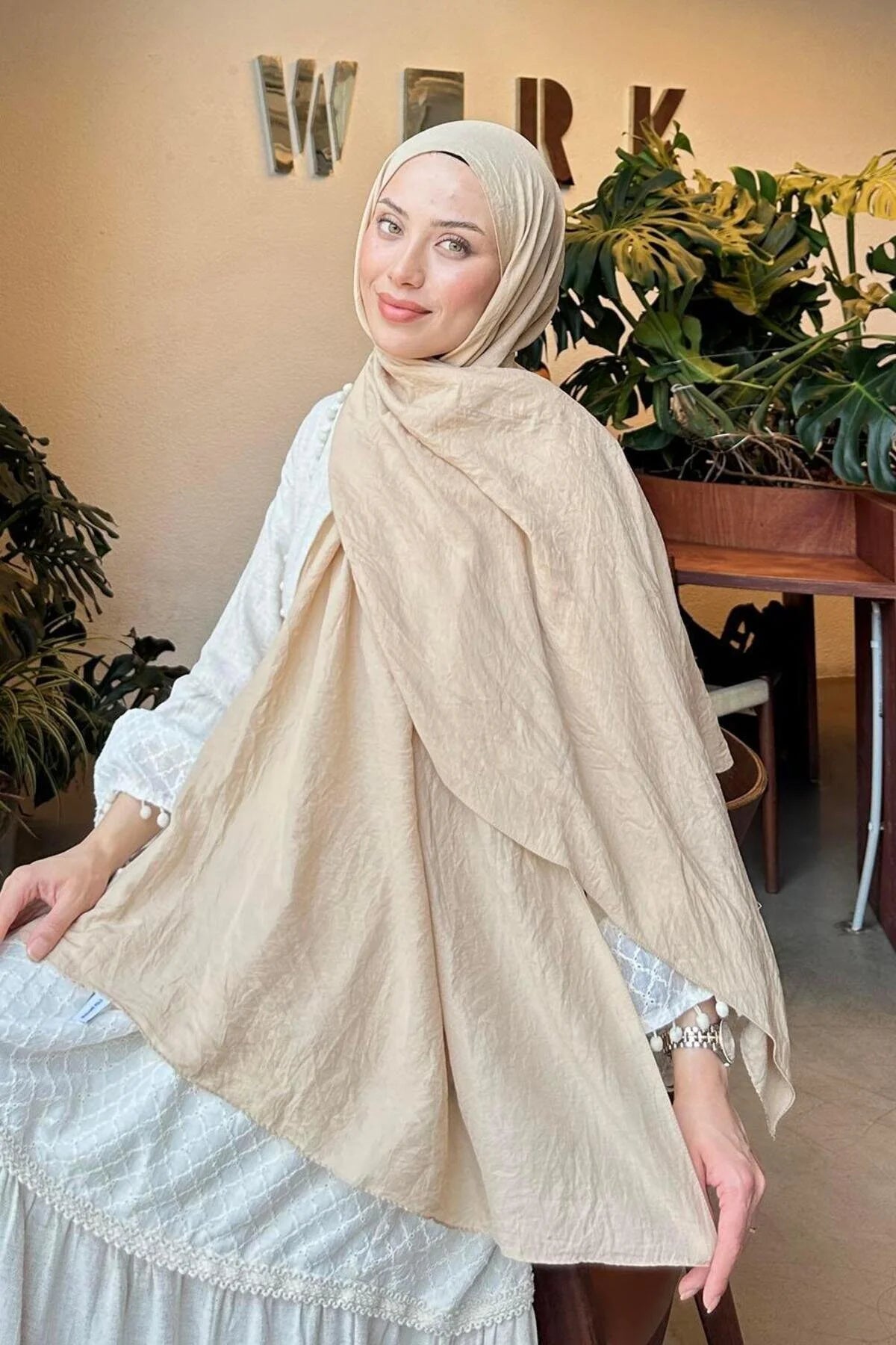Woman in a beige Comfort Cotton Hijab draped loosely over a white dress, front view