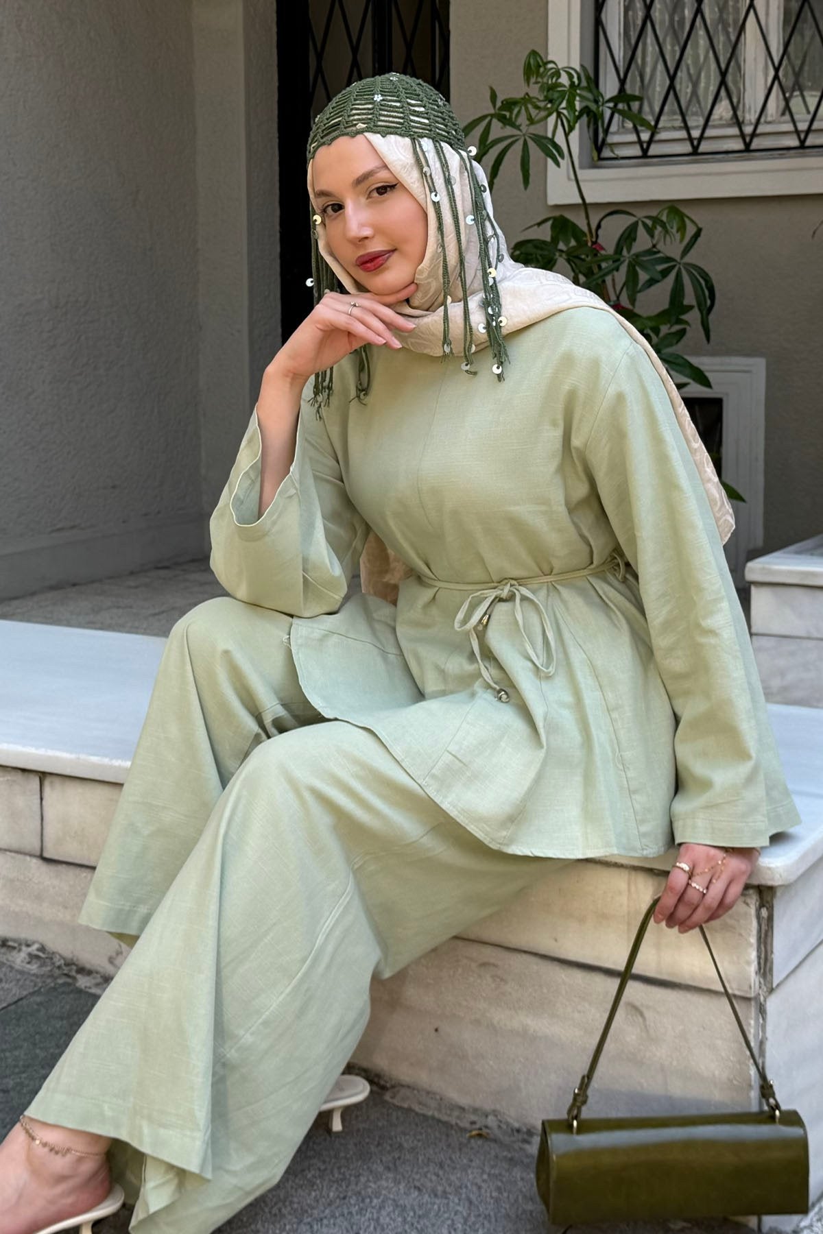 Woman seated on steps wearing the Willow cotton linen set in light green