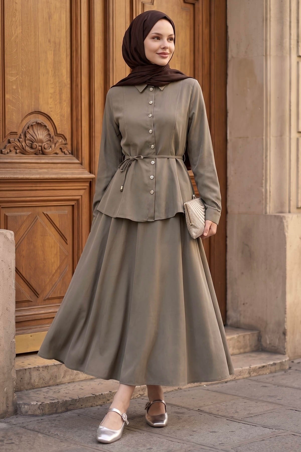 Woman holding out the A-line maxi skirt of the Ayla modest skirt set in taupe