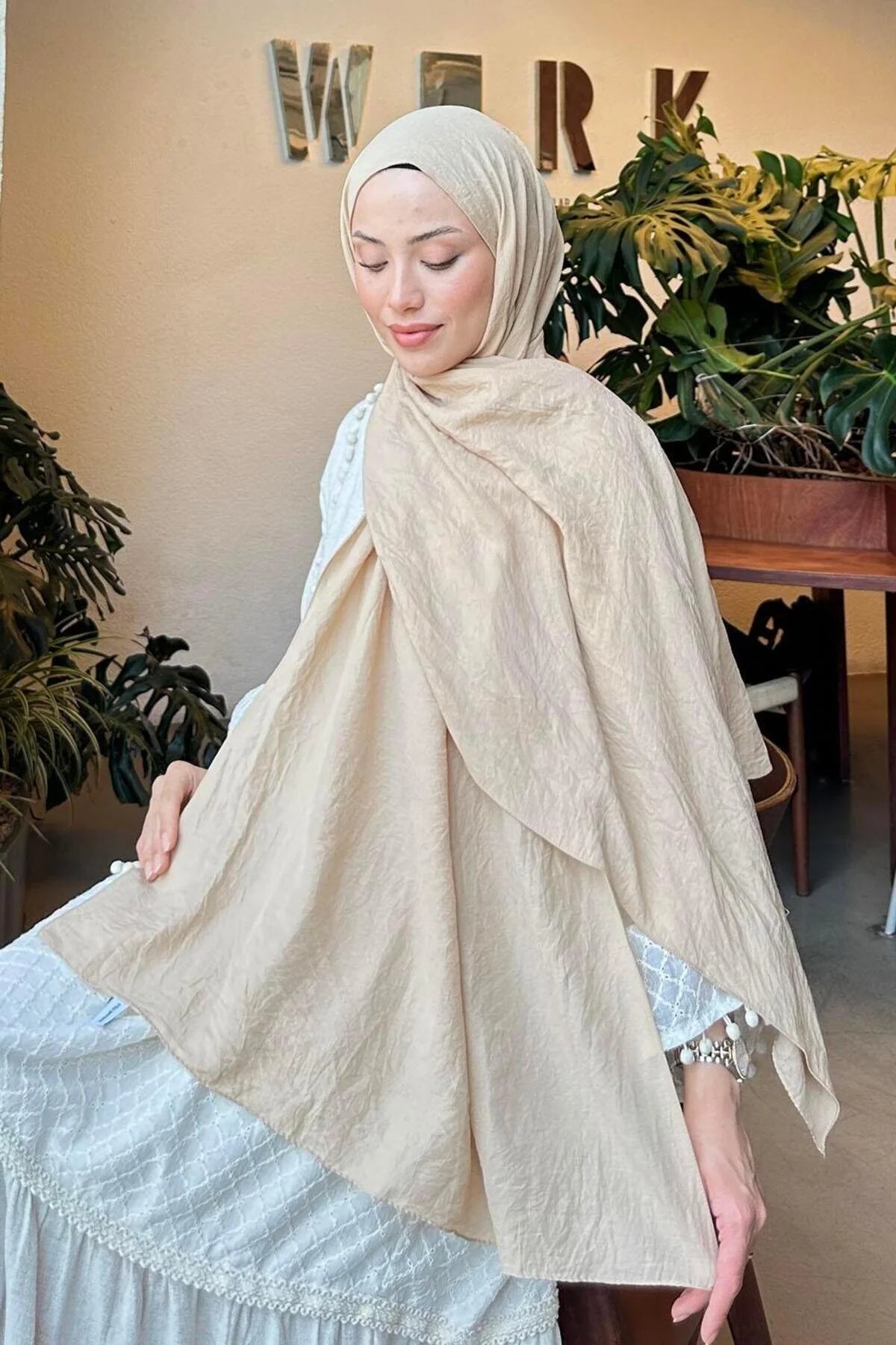 Model holding out the beige Comfort Cotton Hijab to show the soft, breathable fabric