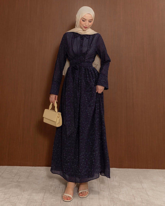 Full-length front view of the MODESTIQUE Fleur Wrap Dress in Navy, worn with a beige hijab and cream bag.