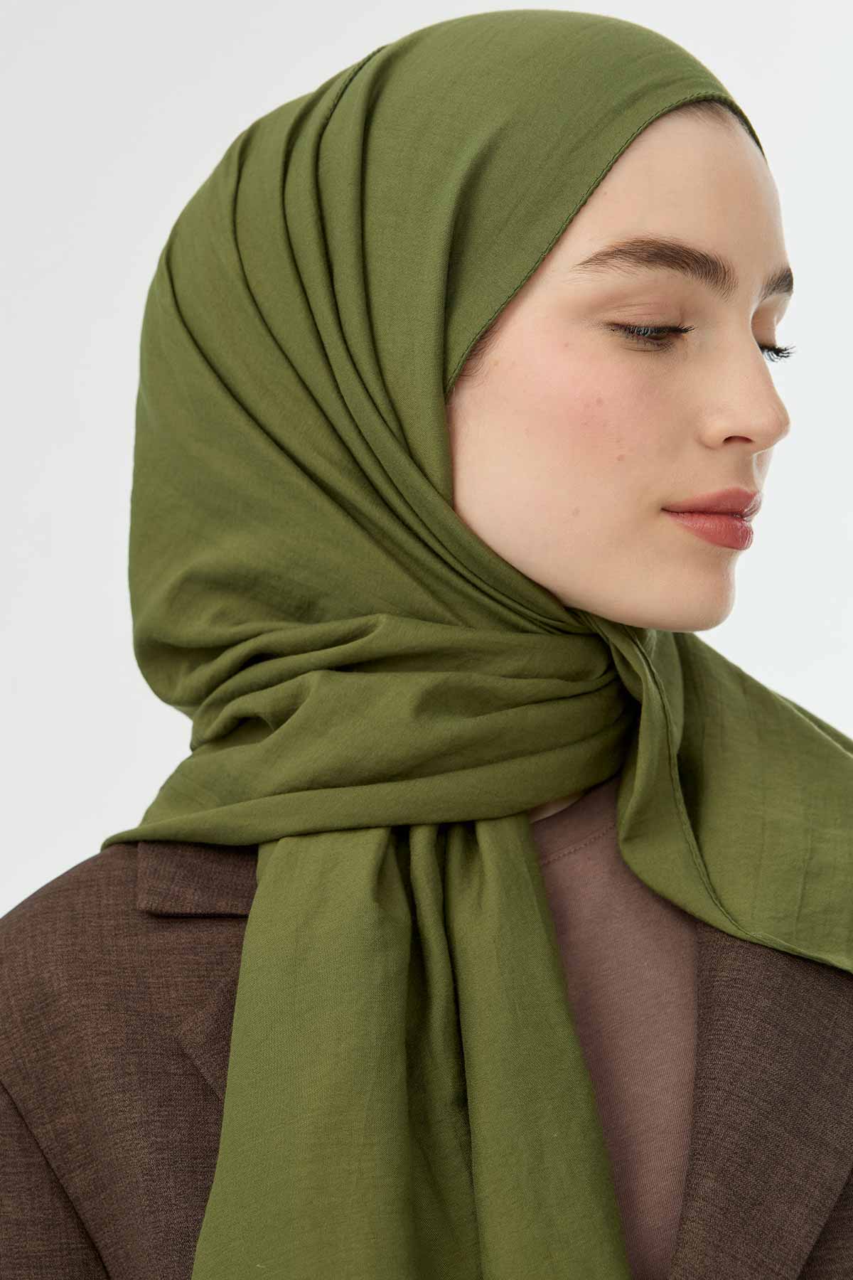 Olive Comfort Cotton Hijab shown in side profile with a brown coat