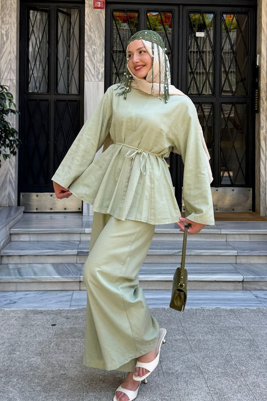 Woman in a hijab wearing the Willow cotton linen set in light green: tie-waist top and relaxed wide-leg pants
