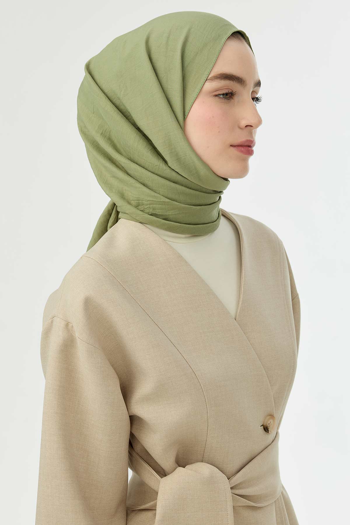 Pistachio Comfort Cotton Hijab styled with a neutral cardigan, three-quarter view